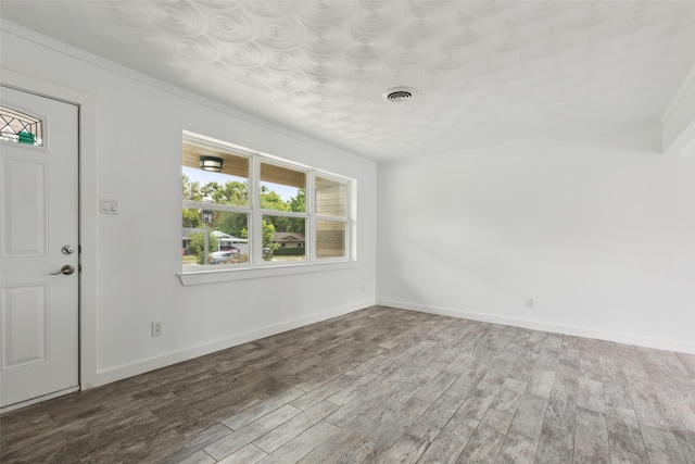 empty room with wood-type flooring and crown molding