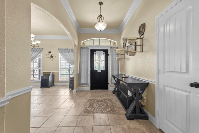 entryway with light tile patterned flooring, a notable chandelier, and crown molding