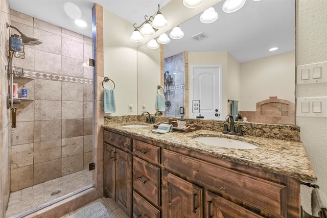 bathroom with a shower with door, double sink vanity, and tile patterned flooring