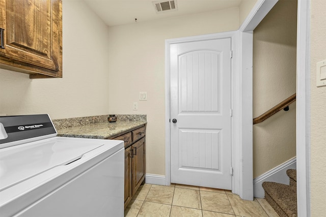 washroom with cabinets, washer / dryer, and light tile patterned floors