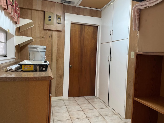 kitchen with wood walls and light tile patterned floors