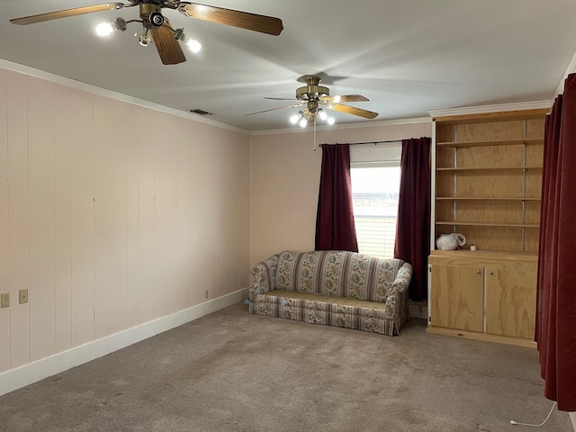 living area with light carpet, ornamental molding, and ceiling fan