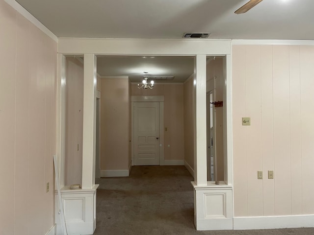 corridor with crown molding, carpet floors, and a chandelier