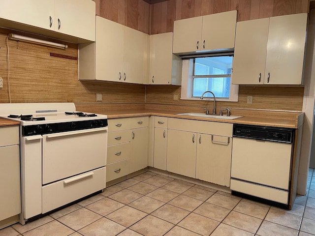 kitchen with sink, white appliances, white cabinets, and light tile patterned flooring