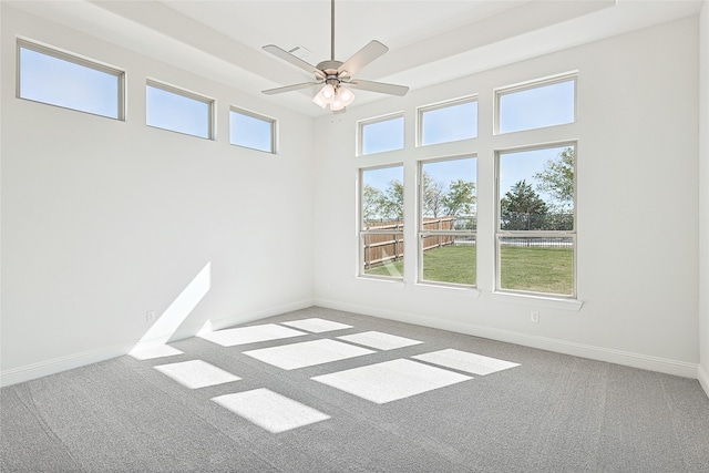 spare room featuring a towering ceiling, carpet floors, and ceiling fan