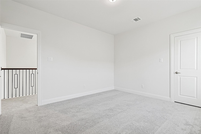 carpeted empty room featuring visible vents and baseboards