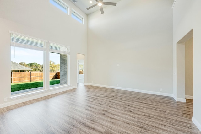2800 Creekhollow Ct, Denton, TX 76226 - unfurnished living room with wood finished floors, a ceiling fan, baseboards, and a towering ceiling