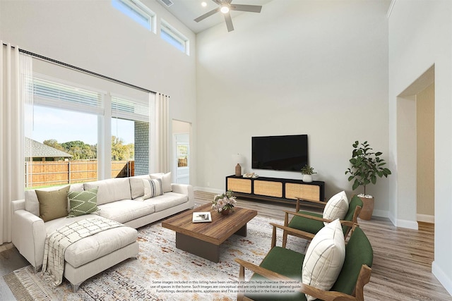 living room with a wealth of natural light, wood-type flooring, and a high ceiling