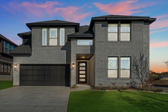 view of front of property with a garage and a yard