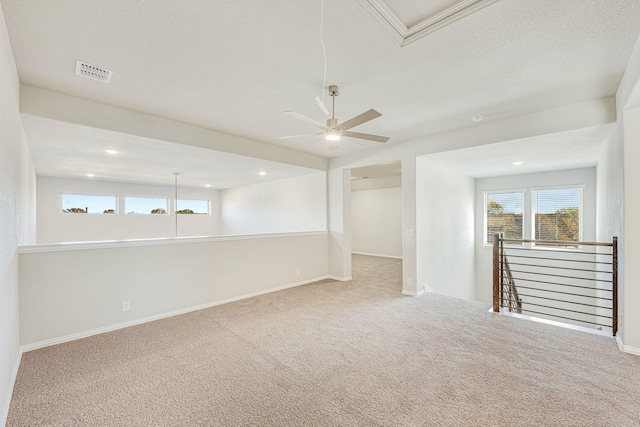 carpeted empty room featuring ceiling fan and a textured ceiling