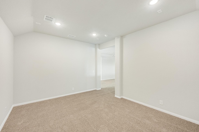 carpeted empty room featuring lofted ceiling