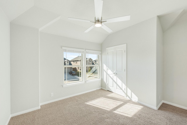 carpeted spare room featuring ceiling fan and lofted ceiling