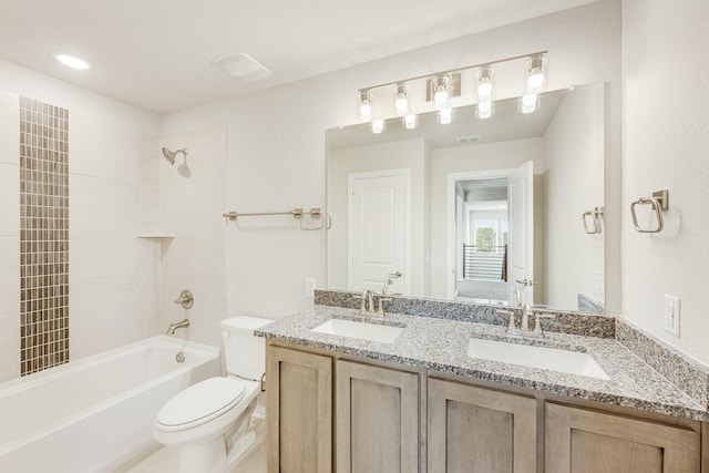 full bathroom with vanity, tiled shower / bath combo, and toilet