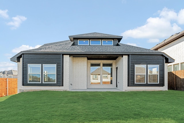 rear view of property featuring a lawn and a patio