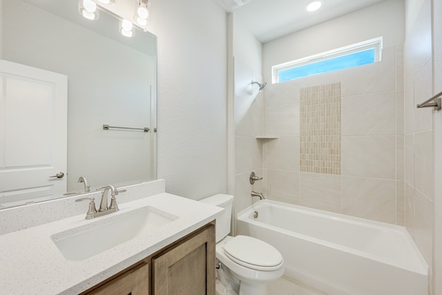 full bathroom with vanity, tiled shower / bath combo, and toilet