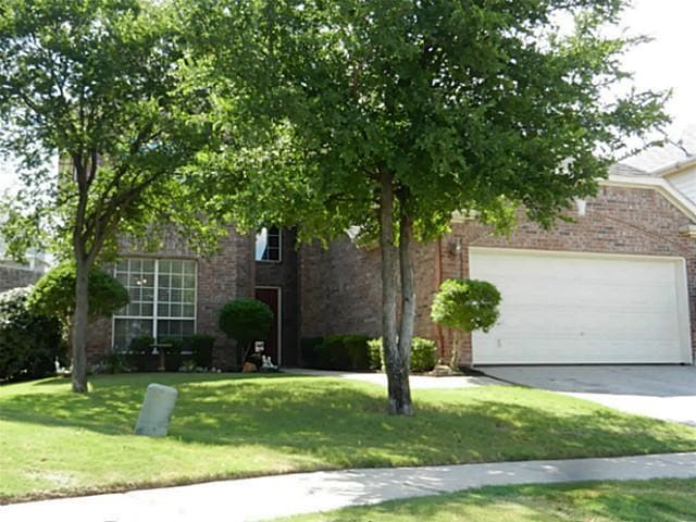 view of property hidden behind natural elements with a front lawn