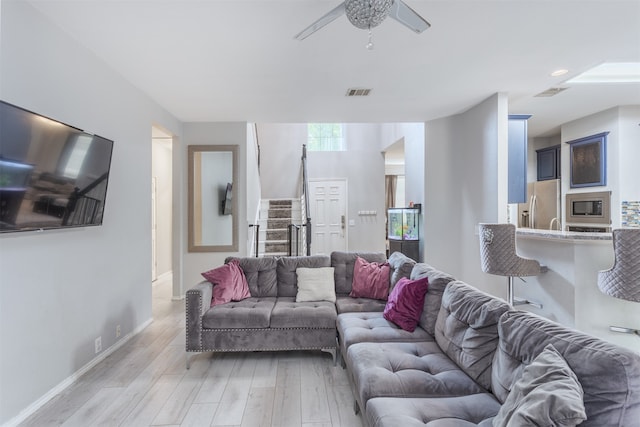 living room with light hardwood / wood-style floors and ceiling fan