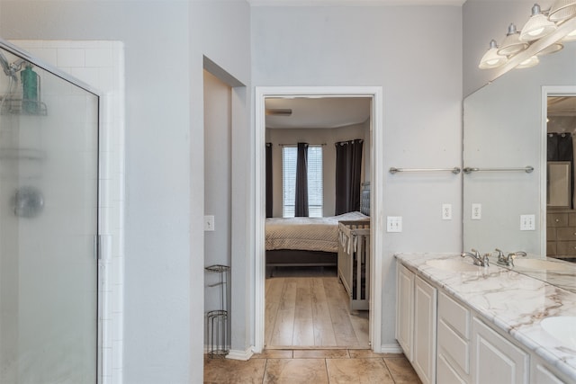 bathroom with dual vanity, a shower with door, and hardwood / wood-style floors