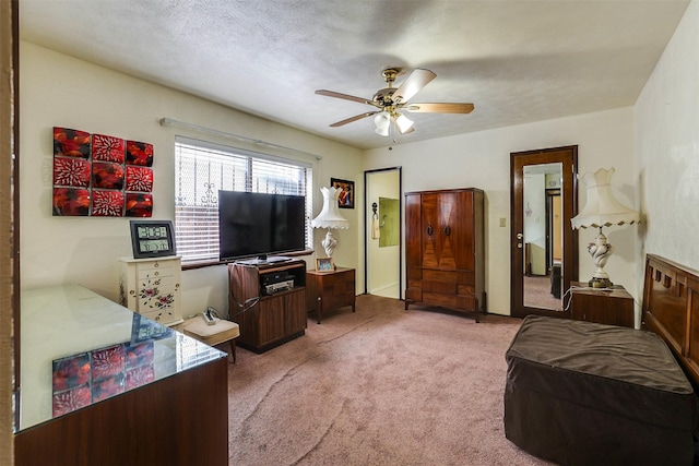 carpeted bedroom with ceiling fan and a textured ceiling