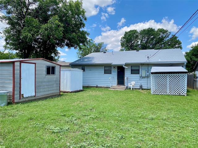 back of property with a lawn and a storage shed