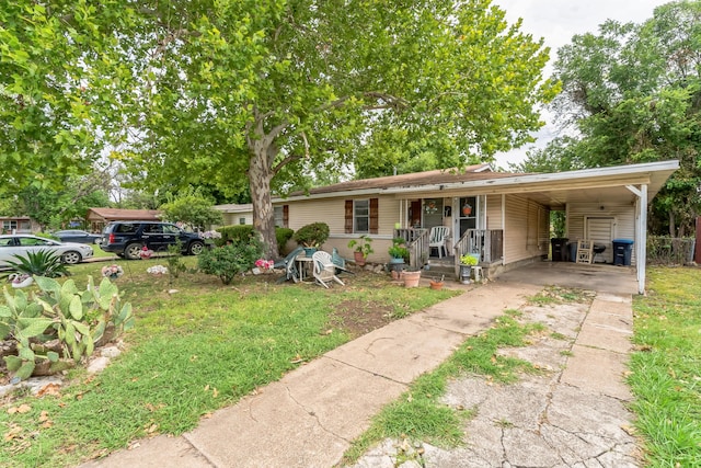 view of front of house with a carport, covered porch, and a front yard