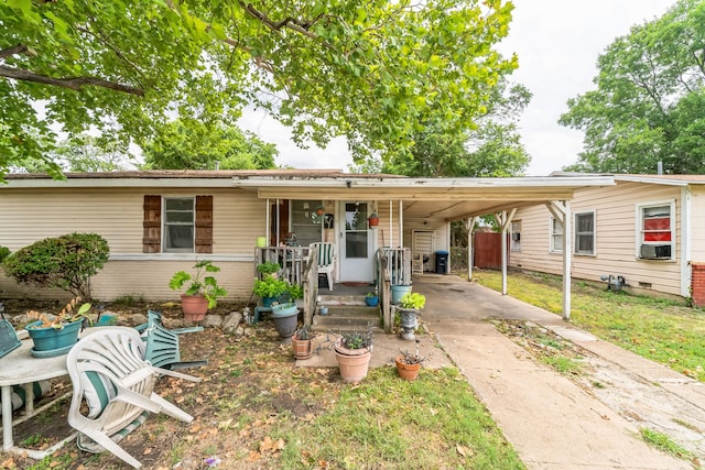 view of front of property featuring cooling unit, a carport, and covered porch