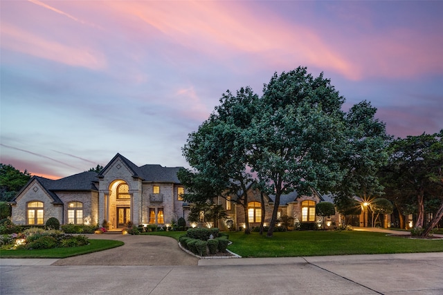 french country inspired facade featuring a lawn