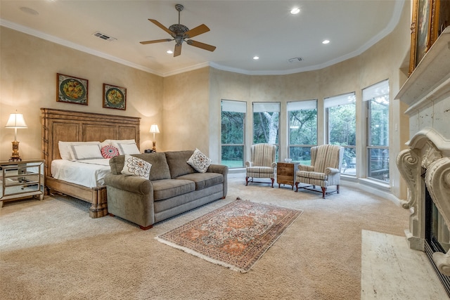 bedroom featuring a high end fireplace, multiple windows, light carpet, and ceiling fan