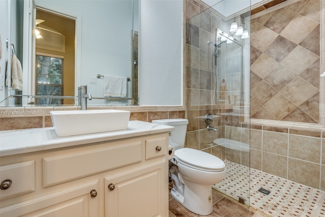 bathroom featuring an enclosed shower, toilet, vanity, tile walls, and tile patterned floors