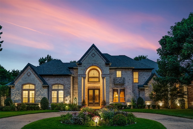 french country inspired facade with a lawn