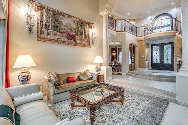 tiled living room with an inviting chandelier, a high ceiling, decorative columns, and french doors