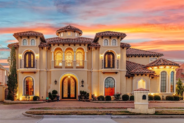 mediterranean / spanish house featuring a balcony and french doors