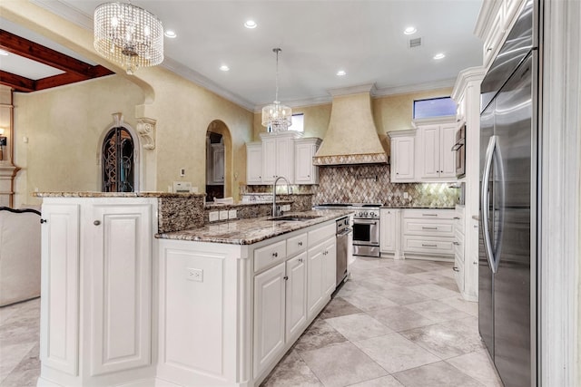 kitchen featuring pendant lighting, sink, a center island with sink, custom range hood, and high quality appliances