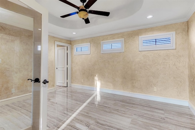 spare room with a raised ceiling, ornamental molding, and ceiling fan