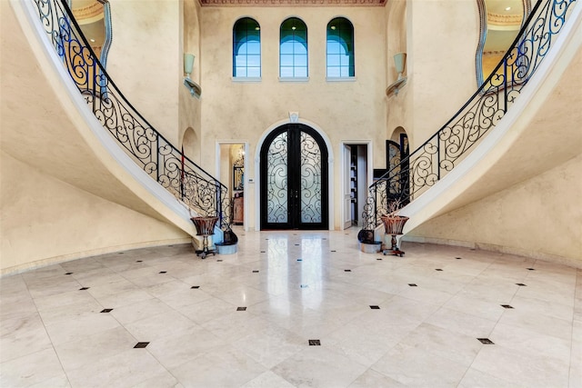 entrance foyer with a high ceiling, french doors, and tile patterned floors