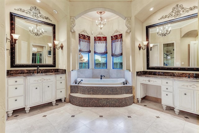 bathroom with an inviting chandelier, tiled tub, vanity, tile patterned floors, and ornamental molding