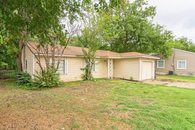 single story home with central air condition unit and a front yard