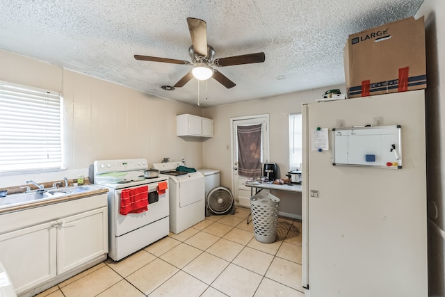 kitchen with white range with electric cooktop, light tile patterned floors, white cabinets, ceiling fan, and washer / dryer