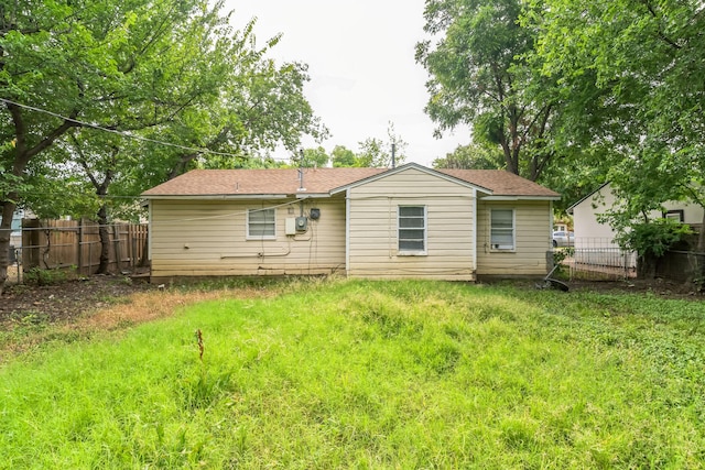 rear view of property featuring a lawn