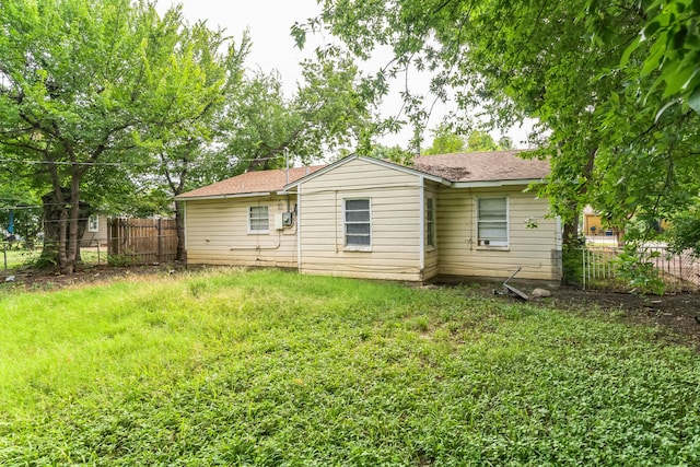 rear view of house featuring a yard