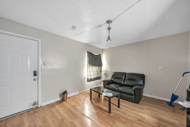 sitting room featuring light hardwood / wood-style floors and a textured ceiling