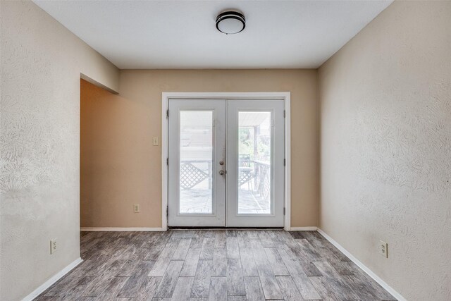 interior space with french doors and hardwood / wood-style floors