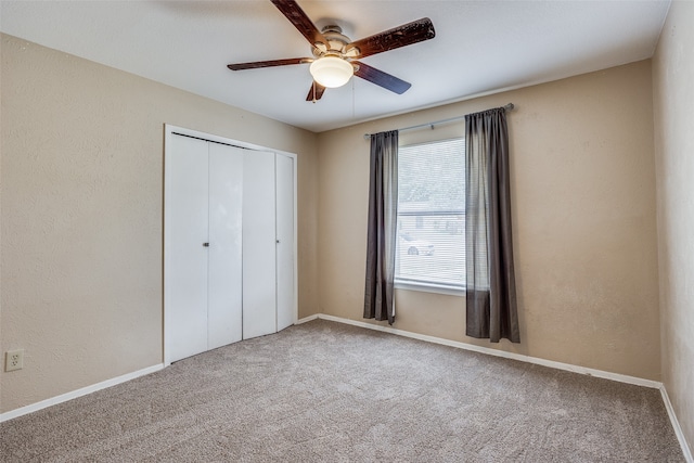 unfurnished bedroom with multiple windows, ceiling fan, carpet flooring, and a closet