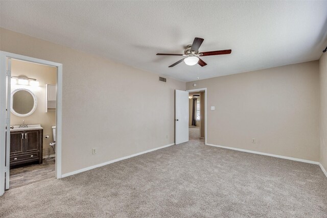 carpeted empty room with sink, a textured ceiling, and ceiling fan