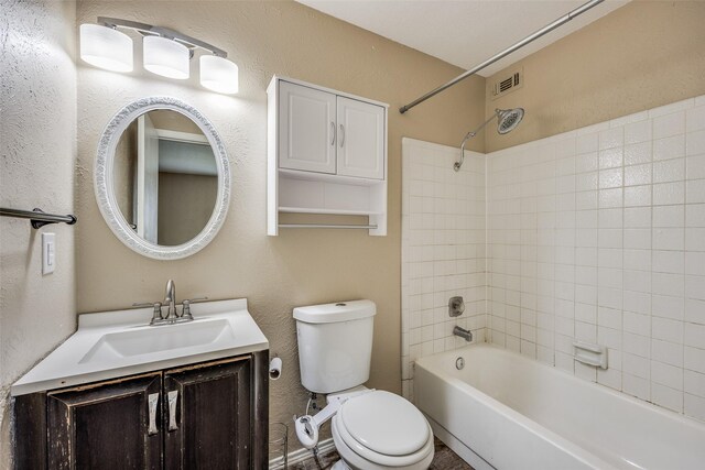 full bathroom featuring toilet, vanity, and tiled shower / bath