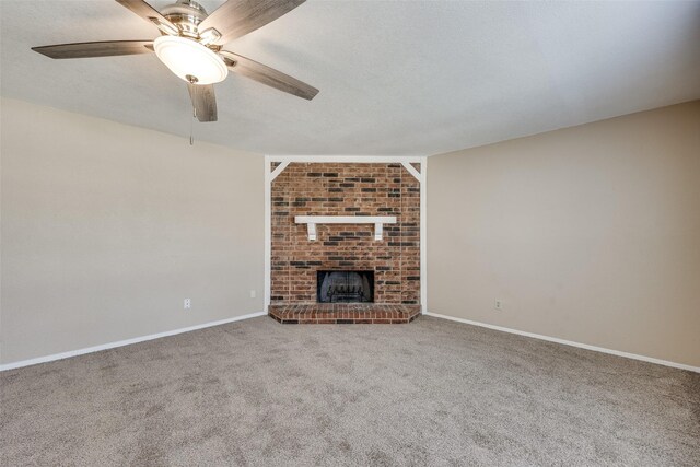 unfurnished living room featuring carpet floors, a fireplace, a textured ceiling, brick wall, and ceiling fan