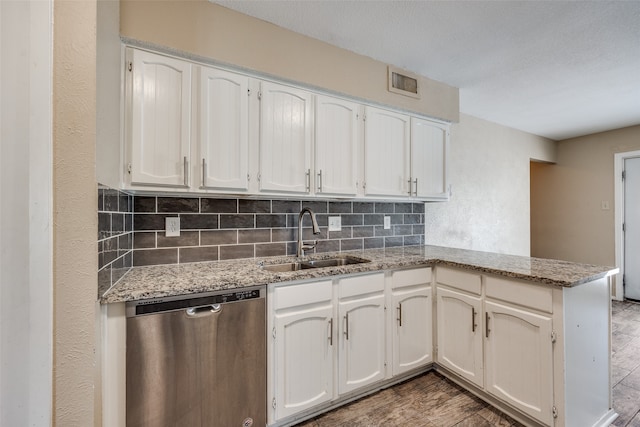 kitchen with decorative backsplash, hardwood / wood-style floors, sink, dishwasher, and kitchen peninsula