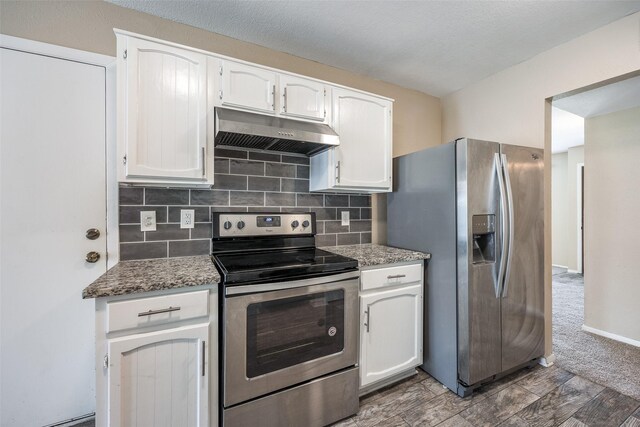 kitchen with white cabinets, stainless steel appliances, backsplash, and dark colored carpet