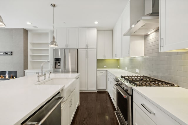 kitchen featuring decorative light fixtures, stainless steel appliances, wall chimney exhaust hood, dark hardwood / wood-style floors, and backsplash