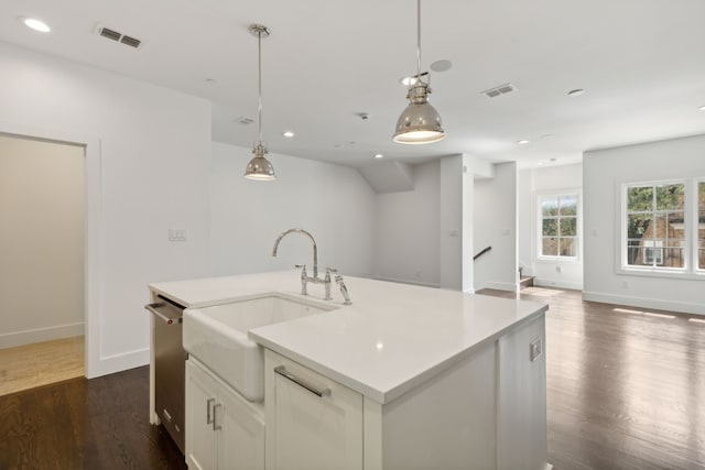 kitchen with dark hardwood / wood-style flooring, pendant lighting, and a center island with sink